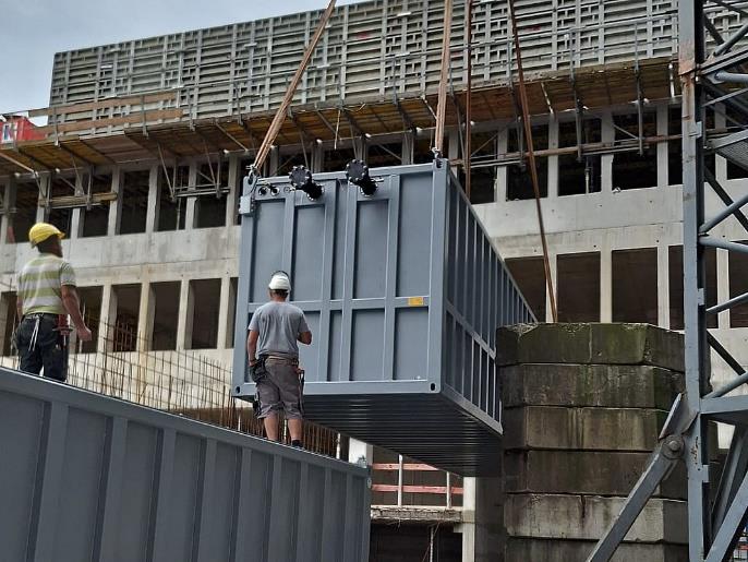 Een ijsaccumodule wordt met een kraan bij het kantoorgebouw van Materna geplaatst